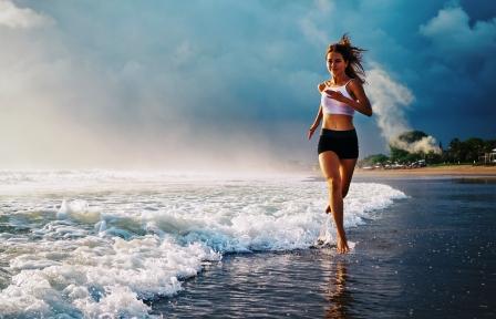 mladá žena sportuje na pláži - běh